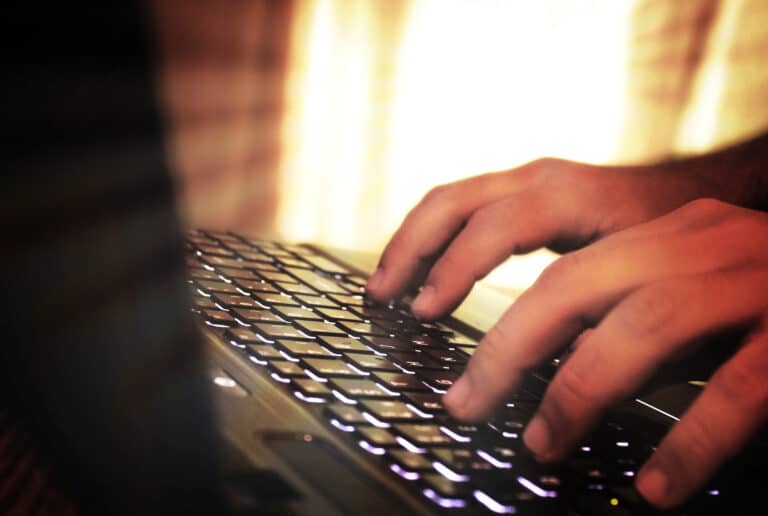 Hands typing on laptop keyboard   fuzzy looks